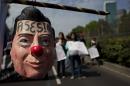 A protestor carries a hanging mask of Mexican President Enrique Pena Nieto marked with the word in Spanish "Assassin" during a march in Mexico City, Monday, Jan. 26, 2015. Protest marches were planned in cities around the country to mark the fourth month since the disappearance of 43 students in southern Guerrero state. The federal prosecutor has said the students were detained by local police and handed over to a drug gang, who killed them and burned their bodies. (AP Photo/Rebecca Blackwell)