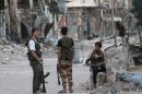 Rebel fighters secure a damaged street in Syria's eastern town of Deir Ezzor on September 23, 2013
