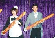 　↑伊林娛樂名模詹乃蓁（左）和余秉諺昨用法國麵包表演儀隊姿勢。（羅永銘攝）
