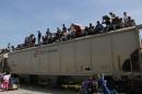 Central American immigrants sit atop the so-called La Bestia (The Beast) cargo train, in an attempt to reach the Mexico-US border, in Arriaga, Mexico on July 16, 2014