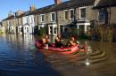 Members of the emergency services paddle down Huntington Road in York, northern England, after the adjacent River Foss burst its banks on December 27, 2015