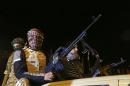 Members of a heavily armed militia group hold their weapons in Freedom Square in Benghazi