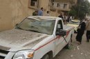 Residents and security personnel gather at the site of an explosion in Deir Al-Zour