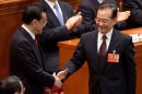Newly-named Chinese Premier Li Keqiang, left, is greeted by his predecessor Wen Jiabao after delegates voted Li as the new premier during a plenary session of the National People's Congress at the Great Hall of the People in Beijing Friday, March 15, 2013. China named the Communist Party's No. 2 leader, Li, premier on Friday as a long-orchestrated leadership transition nears its end, leaving the new leaders to confront uneven economic growth, unbridled corruption and a severely befouled environment that are stirring public discontent. (AP Photo/Andy Wong)