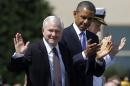 File photo of Robert Gates acknowledging applause from President Barack Obama at the Pentagon