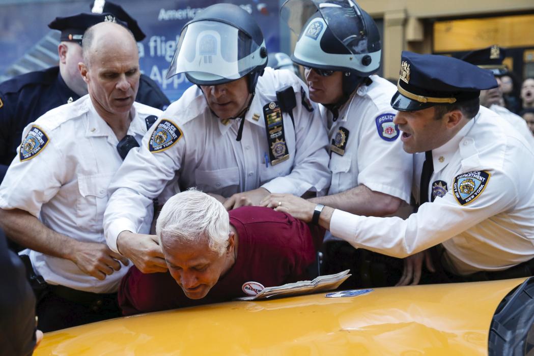 NYPD officers detain a protester during a march through the Manhattan borough of New York City