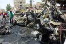 Iraqi men clear the debris at the scene of a car bomb in the mainly Shiite Sadr City district in Baghdad on August 1, 2014