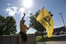 William DePorte waves a Tea Party flag outside a Republican Presidential Debate in Iowa