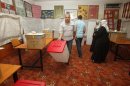 Electoral workers arrange polling materials at a polling station in Tripoli