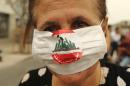 An activist wears a mask during a protest denouncing Lebanon's stagnant political system, which has become the target of demonstrations following a trash crisis, in Beirut's Martyr's square, on September 9, 2015