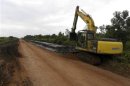 A excavator clears a ditch on a road owned by a disputed palm oil plantation firm near Sebangau Kuala