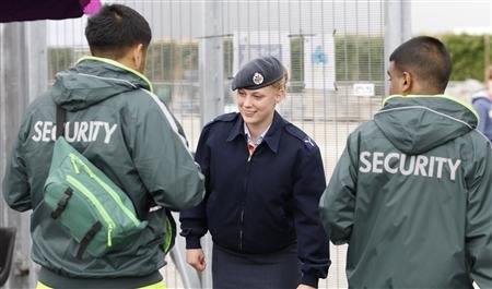 A member of the RAF checks the identifications of two G4S security guards at an exit to the Olympic Park in Stratford, the location of the London 2012 Olympic Games, in east London July 15, 2012. The 