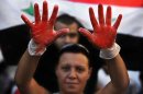 A Lebanese pro-Syrian regime supporter, with her hands painted in red to symbolize blood, attends a demonstration against a possible military strike in Syria, near the U.S. Embassy in Awkar, east of Beirut, Lebanon, Friday, Sept. 6, 2013. The prospect of a U.S.-led strike against Syria has raised concerns of potential retaliation from the Assad regime or its allies. The State Department ordered nonessential U.S. diplomats to leave Lebanon over security concerns and urged private American citizens to depart as well. (AP Photo/Hussein Malla)