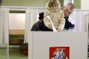 A man with a child casts his ballot at a polling station in Vilnius, Lithuania, Sunday, Oct. 14, 2012. Lithuanians are expected to deal a double-blow to the incumbent conservative government in national elections Sunday by handing a victory to opposition leftists and populists and saying 'no' to a new nuclear power plant that supporters claim would boost the country's energy independence. (AP Photo/Mindaugas Kulbis)