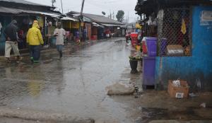 People walk under the rain in a street of the West …