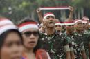 Locals and soldiers sing the national anthem during a military-sponsored interfaith rally held ahead of the planned Dec. 2, Muslim protest against Jakarta Governor Basuki Tjahaja Purnama in Jakarta, Indonesia, Wednesday, Nov. 30, 2016. Thousands of Indonesians have joined interfaith rallies around the country organized by the military in an attempt to demonstrate national unity as religious and racial tensions divide the world's largest Muslim nation. (AP Photo/Achmad Ibrahim)