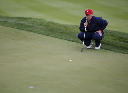 U.S. team Spieth studies a putt on the first green during their singles matches of the 2015 Presidents Cup golf tournament at the Jack Nicklaus Golf...