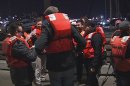 This image provided by KTVU-TV shows some of the 22 rescued passengers on the pier Friday Oct.12, 2012 in San Francisco. A U.S. Coast Guard spokesman said the wine-tasting boat, Neptune hit a shoal near Alcatraz Island and began sinking. Nearly two dozen people who were enjoying a boat ride on what's billed as San Francisco Bay's only "floating wine tasting room" are OK after their vessel hit a shoal near Alcatraz Island and started sinking Friday night. U.S. Coast Guard spokesman Lt. j.g. Josh Dykman says the 45-foot Neptune hit the shoal around 8:42 p.m. and started taking on water after the impact left a 1-foot gash in the side of the boat. The boat's captain tried to get it back to Pier 39, where the boat is docked, but the captain had difficulty navigating the vessel and it started sinking. Dykman says three Coast Guard boats took all 22 passengers and crewmembers off the vessel and brought them back to the pier. There were no injuries.(AP Photo/KTVU-TV)