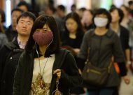 Mulheres usam máscaras contra o vírus H7N9 em 16 de abril de 2013, em Xangai