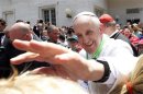 Pope Francis extends his hand as he welcomes more than 250 children, who travelled on a special train from Milan to meet him, at St. Peter train station in the Vatican