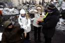 Volunteers distribute borshch to anti-government protesters near a barricade at the site of clashes with riot police in Kiev