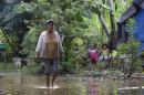 A woman walks in a flooded area of their home near the Ibare river in Trinida