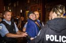 A man is arrested by police outside the Parti Quebecois victory rally in Montreal on Wednesday, Sept. 5, 2012. A masked gunman wearing a blue bathrobe opened fire during a midnight victory rally for Quebec's new premier, killing one person and wounding another. The new premier, Pauline Marois of the separatist Parti Quebecois, was whisked off the stage by guards while giving her speech and uninjured. It was not clear if the gunman was trying to shoot Marois, whose party favors separation for the French-speaking province from Canada. Police identified the gunman only as a 62-year-old man, and were still questioning him Wednesday morning. (AP Photo/Montreal La Presse via The Canadian Press, Olivier Pontbriand)