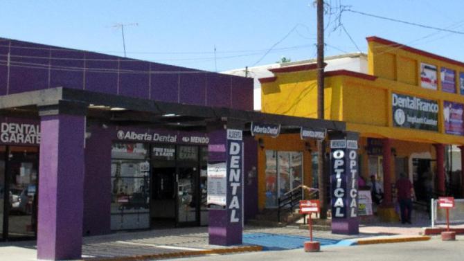 In this Thursday, April 30, 2015 photo, a street full of a dental offices is seen in Los Algodones, Mexico, which sits on the border with California. Thousands of Americans and Canadians travel to Los Algodones each year for affordable and reliable dental work from dentists who speak English and sometimes accept U.S. insurance. The trip, even counting the cost of traveling long distances, is often more affordable than getting dental care in the United States. (AP Photo/Astrid Galván)