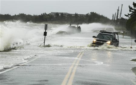 Caminhonete sofre para passar pela inundação causada pelas fortes ondas em Southampton, Nova York.
