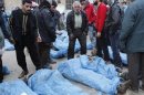 Residents attempt to identify bodies found along a river, at a school used as a field hospital in Aleppo's Bustan al-Qasr