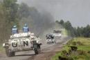 U.N. peacekeepers drive tank as they patrol past deserted Kibati village