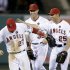 Los Angeles Angels center fielder Mike Trout, left, Josh Hamilton and Peter Bourjos celebrates their 10-9 win against the Seattle Mariners during a baseball game in Anaheim, Calif., Thursday, June 20, 2013. (AP Photo/Chris Carlson)