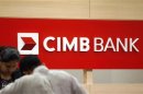 A staff attends to a customer at a branch of CIMB Bank in Kuala Lumpur