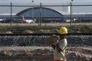 Worker carries a rock at the site of the delayed construction of a new terminal at the Pinto Martins International Airport in Fortaleza