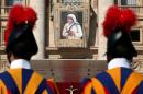 Swiss Guards stand in front of a tapestry depicting Mother Teresa of Calcutta before a mass, celebrated by Pope Francis, for her canonisation in Saint Peter's Square at the Vatican