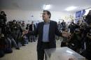 Alexis Tsipras, leader of Greece's Syriza left-wing main opposition party surrounded by photographers reacts as he casts his vote at a polling station in Athens, Sunday, Jan. 25, 2015. Greeks were voting Sunday in an early general election crucial for the country's financial future, with the radical left Syriza party of Alexis Tsipras tipped as the favorite to win, although possibly without a large enough majority to form a government. (AP Photo/Lefteris Pitarakis)