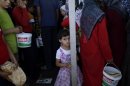 A Syrian girl, bottom center, who fled her home, due to fighting between the Syrian army and the rebels, waits her turn to buy bread and eggs from a store, as she and others take refuge at the Bab Al-Salameh border crossing, in hopes of entering one of the refugee camps in Turkey, near the Syrian town of Azaz, Monday, Sept. 3, 2012. (AP Photo/Muhammed Muheisen)