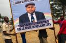 Supporters of Etienne Tsisekedi carry a sign with his portrait in Kinshasa, on July 27, 2016 as the veteran opposition chief comes home