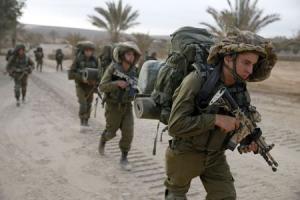 Israeli soldiers walk outside the Gaza Strip as they &hellip;