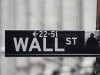 A Wall Street sign is seen in front of the exterior of the New York Stock Exchange
