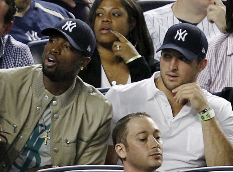 Tim Tebow, right, with Dwyane Wade at a 2012 New York Yankees game (AP) 