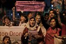 Pakistanis and American citizens hold banners and chant slogans against drone attacks in Pakistani tribal belt, in Islamabad, Pakistan, Friday, Oct. 5, 2012. A group of American anti-war activists are in Pakistan with plans to join a 