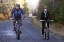 Nurse Kaci Hickox, right, and her boyfriend, Ted Wilbur are followed by a Maine State Trooper as they ride bikes on a trail near her home in Fort Kent, Maine, Thursday, Oct. 30, 2014. The couple went on an hour-long ride. State officials are going to court to keep Hickox in quarantine for the remainder of the 21-day incubation period for Ebola that ends on Nov. 10. Police are monitoring her, but can't detain her without a court order signed by a judge. (AP Photo/Robert F. Bukaty)