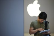 This file photo shows a customer using his iPad outside an Apple store in Shanghai, on June 28. Apple, which is expected to launch a mini version of its market-leading iPad tablet, could quickly overpower its rivals in the segment with the addition of the new product, analysts say