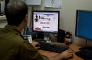 An Israeli soldier looks at the Facebook page of the IDF, at the IDF spokesperson office in Jerusalem, Thursday, Nov. 15, 2012. The hostilities between Israel and Hamas have found a new battleground: social media. The Israeli Defense Force and Hamas militants have exchanged fiery tweets throughout the fighting in a separate war to influence public opinion. (AP Photo/Sebastian Scheiner)