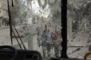Boys are pictured through a broken windshield as they stand on a street in Aleppo