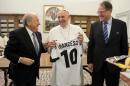 In this photo provided by the Vatican newspaper L'Osservatore Romano Pope Francis is presented with a jersey reading his name during a meeting with FIFA president Joseph Sepp Blatter, left, at the Vatican Friday, Nov. 22, 2013. "We spoke the same language and it was language of football," Blatter said during a press conference following the meeting, ' It was really a meeting between two sportsmen and two football fans."(AP Photo/L' Osservatore Romano, ho)