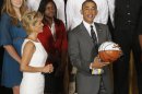 President Barack Obama stands with head coach Kim Mulkey as he is presented with a jersey and a basketball at a ceremony honoring the 2012 NCAA Women's basketball champions Baylor University Bears in the East Room at the White House in Washington, Wednesday, July 18, 2012. (AP Photo/Charles Dharapak)