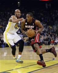 Miami Heat's Mario Chalmers, right, dribbles past Golden State Warriors' Jarrett Jack (2) during the first half of an NBA basketball game in Oakland, Calif., Wednesday, Jan. 16, 2013. (AP Photo/Marcio Jose Sanchez)