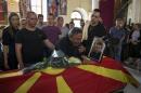 Relatives of killed policeman Samoilovski mourn next to his coffin covered in Macedonian flag inside a churc in town of Tetovo